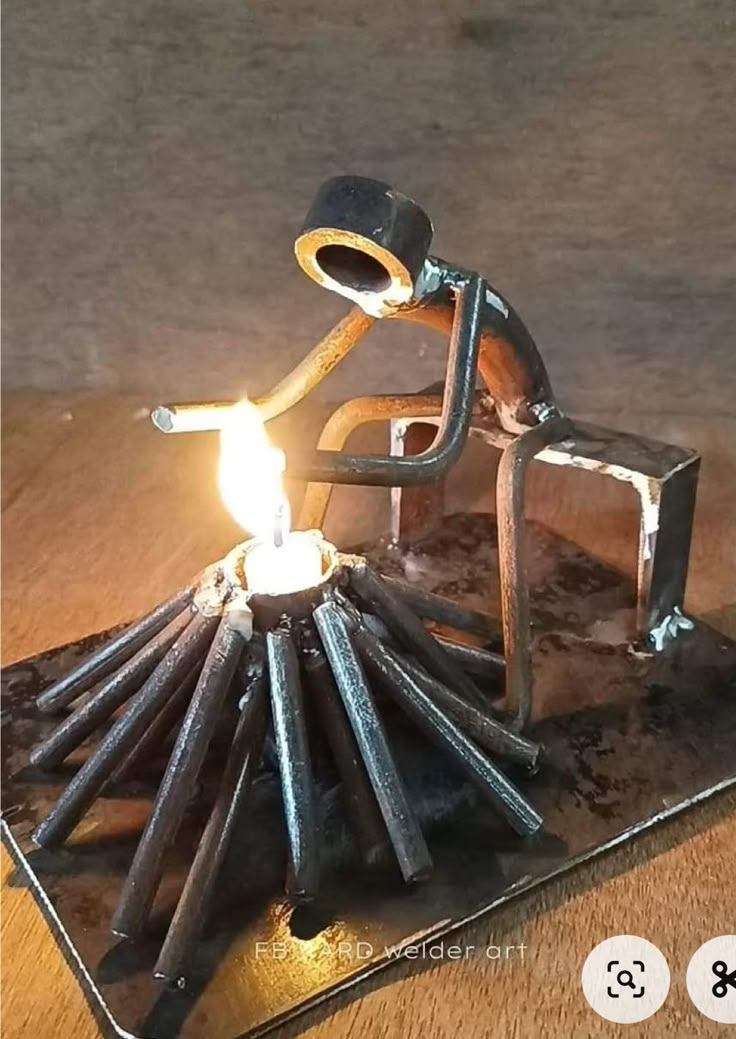 a candle holder made out of sticks and a man sitting on top of it with a lighter in his hand