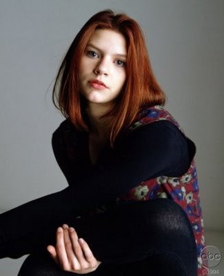 a woman with red hair sitting on the floor