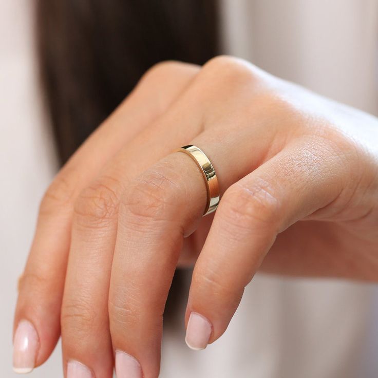 a woman's hand with a gold ring on it