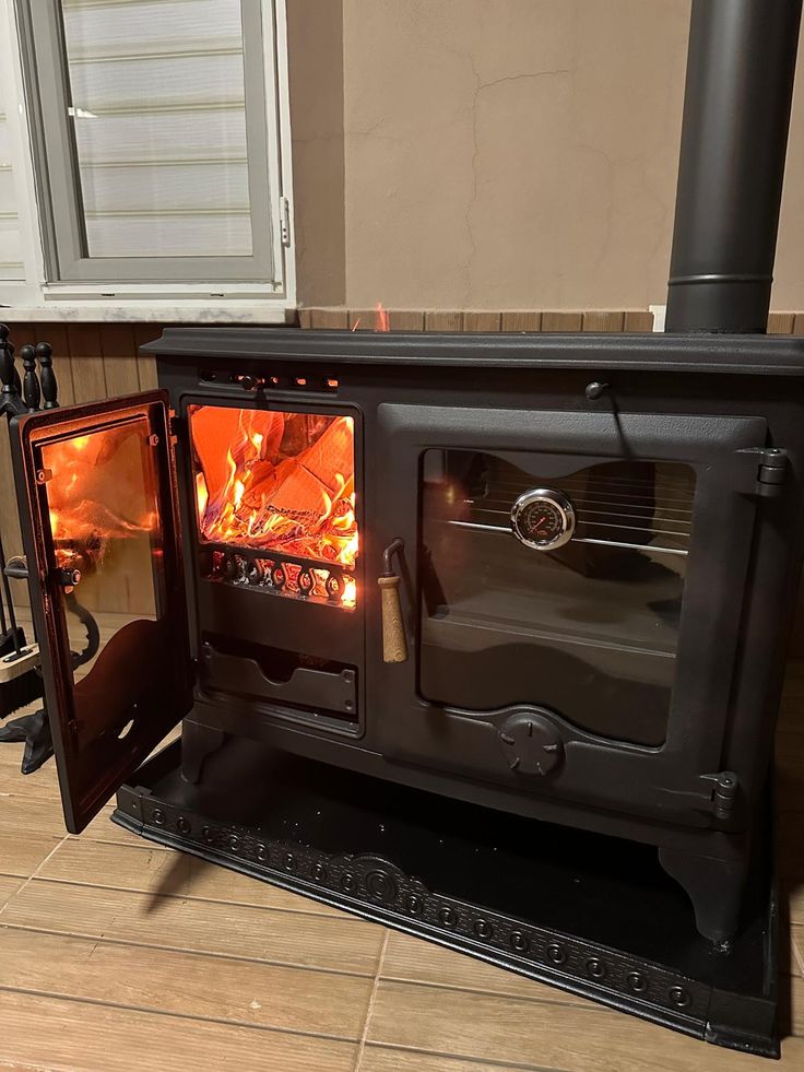 an open fire place in the middle of a kitchen with tile flooring and walls