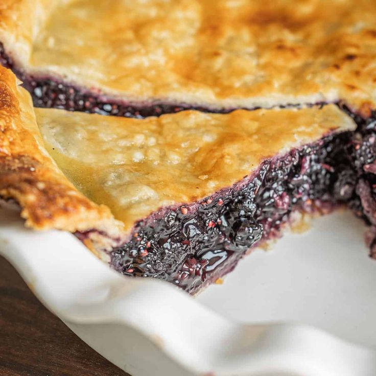 a piece of blueberry pie sitting on top of a white plate