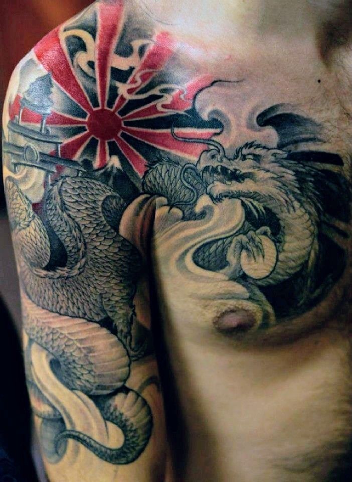 a man's chest and arm with tattoos on it, including an image of a dragon