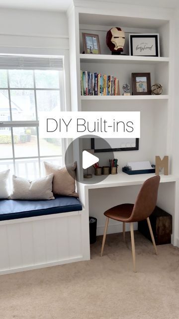 a white desk sitting under a window next to a book shelf with books on it