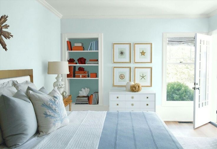 a bed room with a neatly made bed and a book shelf on the wall above it