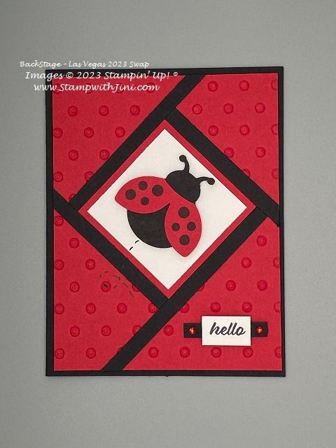 a red and black card with a ladybug design on it's side