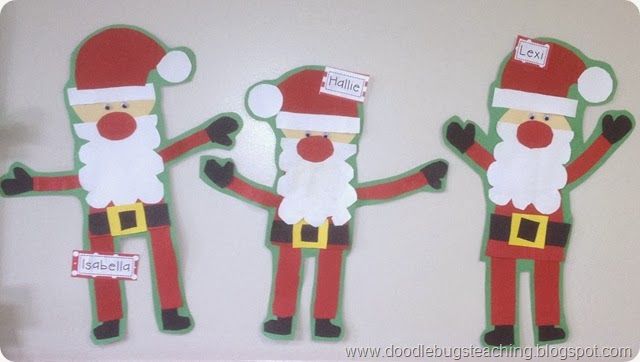 three paper cutouts of santa clauses on a white surface, one with his hands in the air