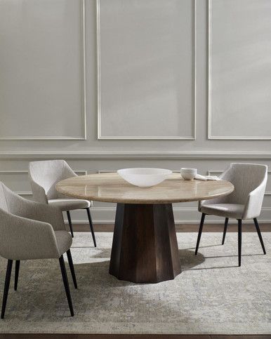 a round table with four chairs around it in a living room next to a white wall