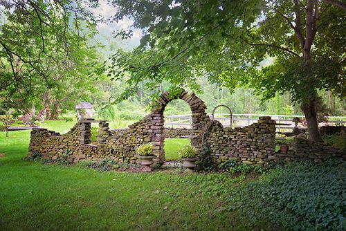 an old stone wall in the middle of a park