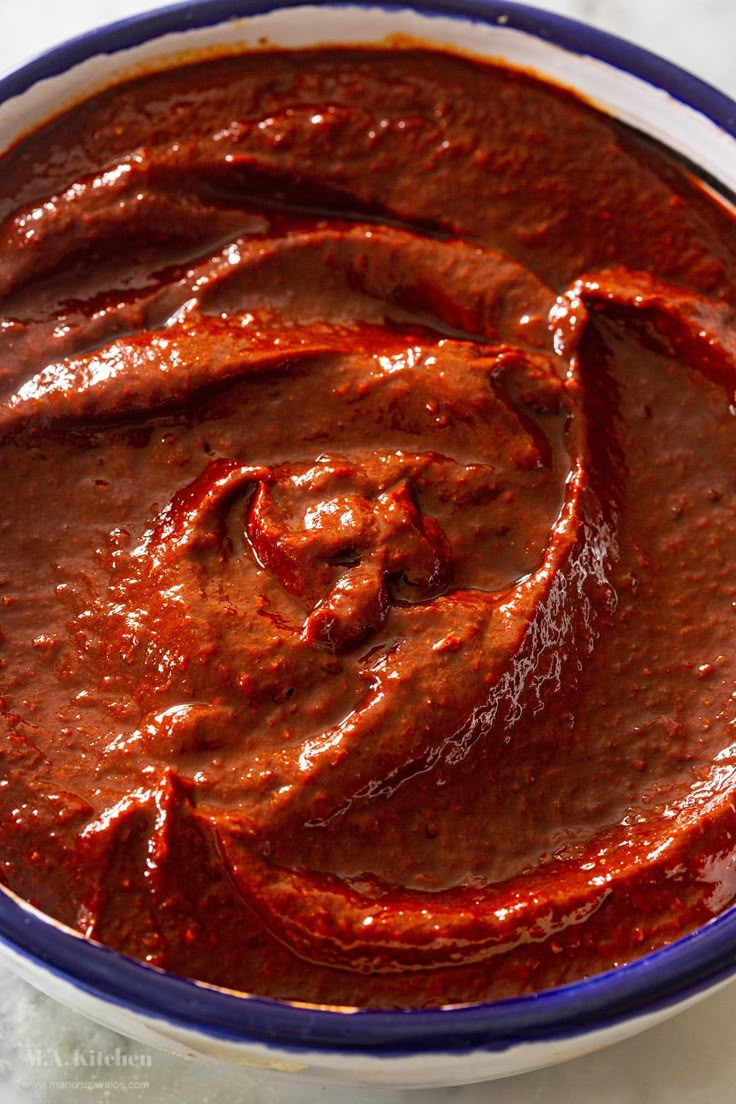 a bowl filled with red sauce on top of a table