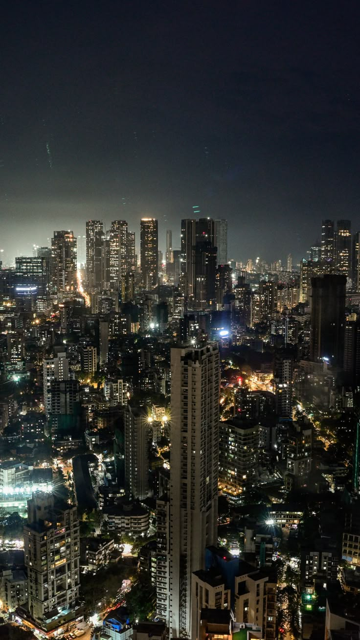 the city lights shine brightly at night in this aerial view from an observation point on top of a skyscraper