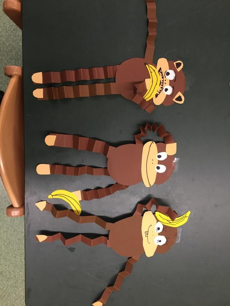 paper cut out of monkeys sitting on top of a table