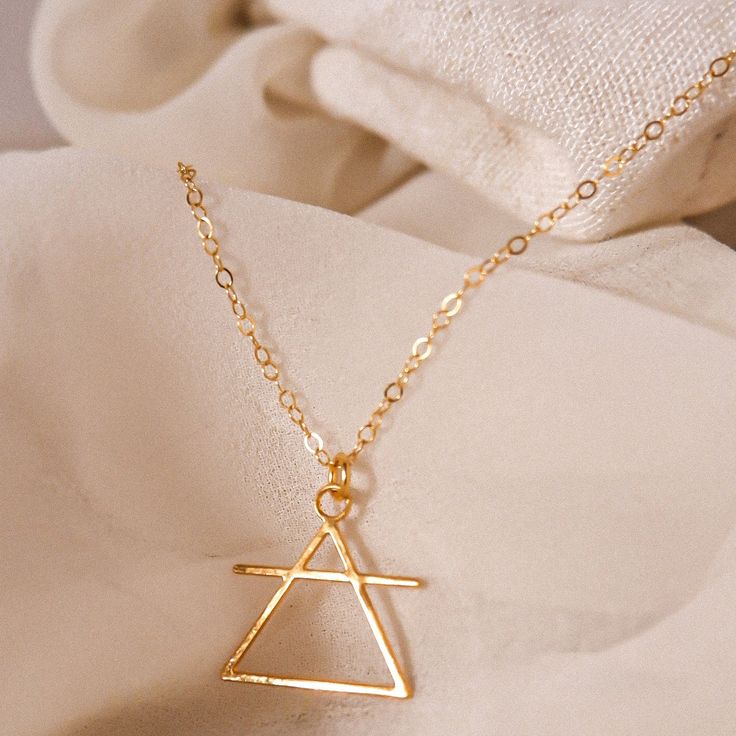 Jewelry with Meaning Triangle Necklace | For Air Signs DESIGNER'S NOTES: Easy to wear and stylish, this design fuses traditional motifs and modern elements, resulting in a great meaningful everyday necklace. This symbol stems back to Grecian times when alchemists used it as a short-hand for the element of Air. Key Features: Symbolic Design: Symbolizes the element of air which is associated with thought, intellect, and innovation. Understated Elegance: Cast in a fetching gold or cool, silver-tone Air Symbol, Element Of Air, Short Hand, Element Necklace, Meaningful Necklace, Air Signs, Symbols And Meanings, Traditional Motifs, Triangle Necklace