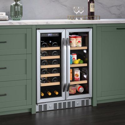 a wine cooler in the middle of a kitchen with green cabinets and countertop space