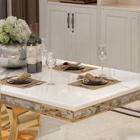 a dining room table with place settings and wine glasses on the top, in front of an oven