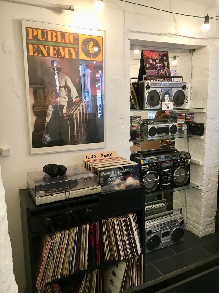 there is a record player on the shelf next to other records and audio equipment in this room