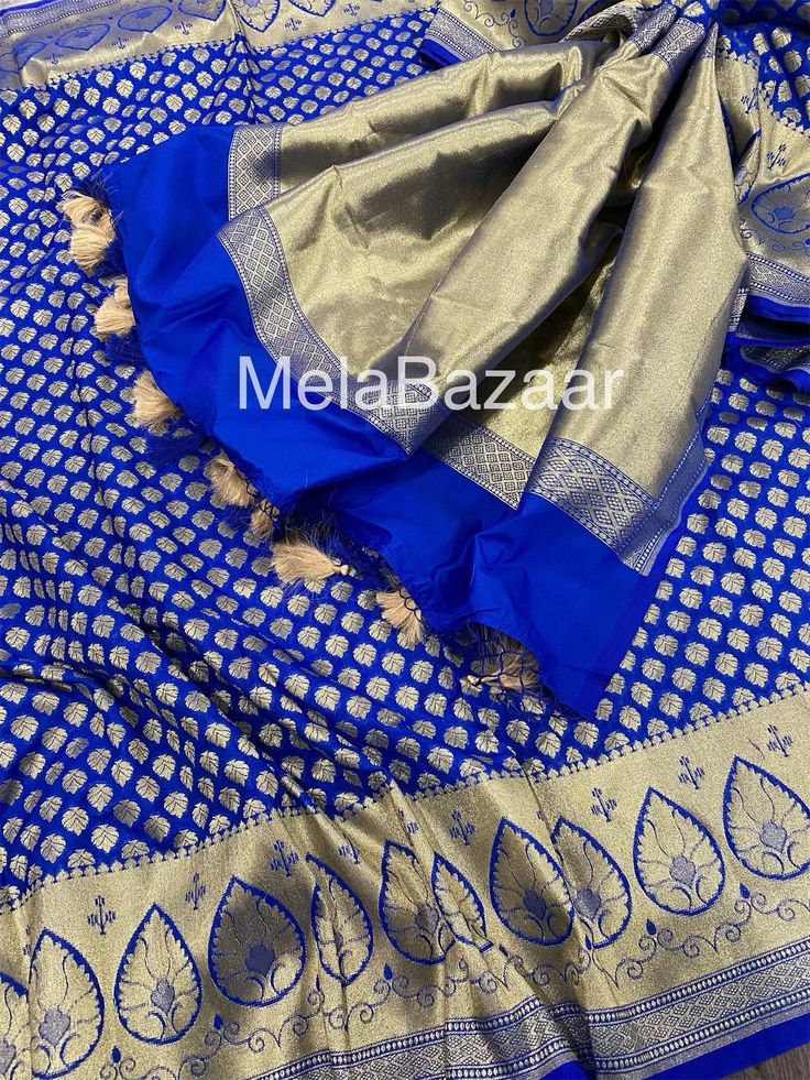 Dazzling royal blue Katan silk blend Banarsi saree. Dense gold  zari butas and tassels on the palla! Blouse fabric included. Fall attached. Note: The color of the products may slightly vary according to the lighting conditions and the color calibration of the viewing LED devices. If you would like more clarity before your purchase, please drop us a message . Blue Tissue Silk Blouse Piece For Transitional Season, Bollywood Style Royal Blue Saree For Eid, Blue Tissue Silk Traditional Wear For Festive Occasions, Blue Tissue Silk Dupatta For Festive Occasions, Royal Traditional Wear With Pallu For Eid, Royal Traditional Wear With Drape For Eid, Royal Traditional Wear With Traditional Drape For Eid, Festive Blue Tissue Silk Dupatta, Blue Tissue Silk Blouse Piece With Pallu