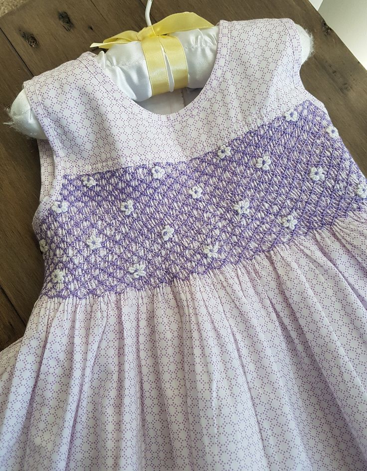 a purple and white dress sitting on top of a wooden floor