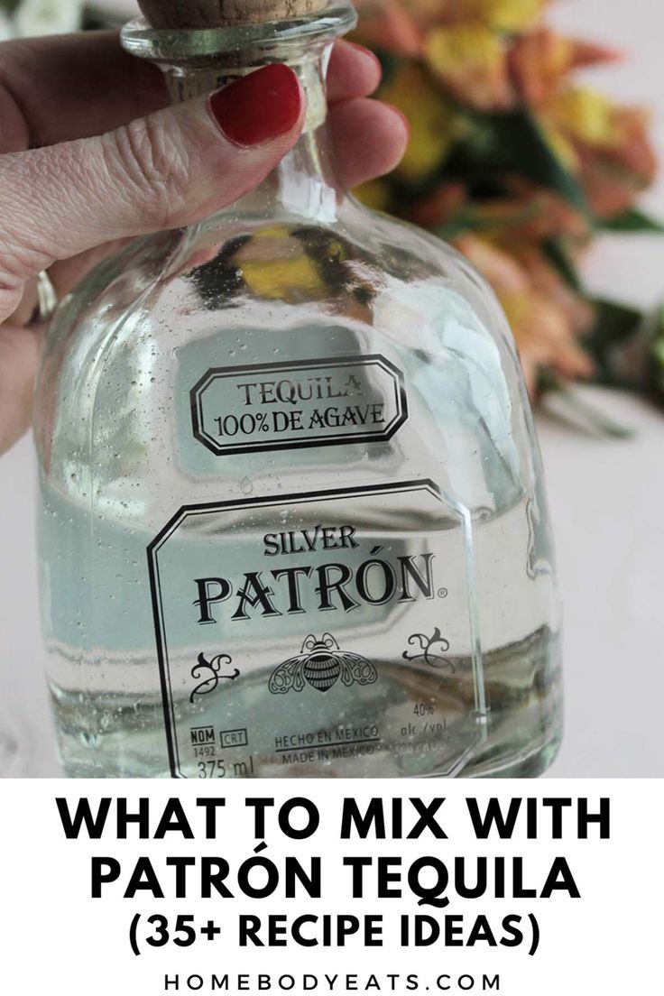 a hand holding a bottle of silver patron