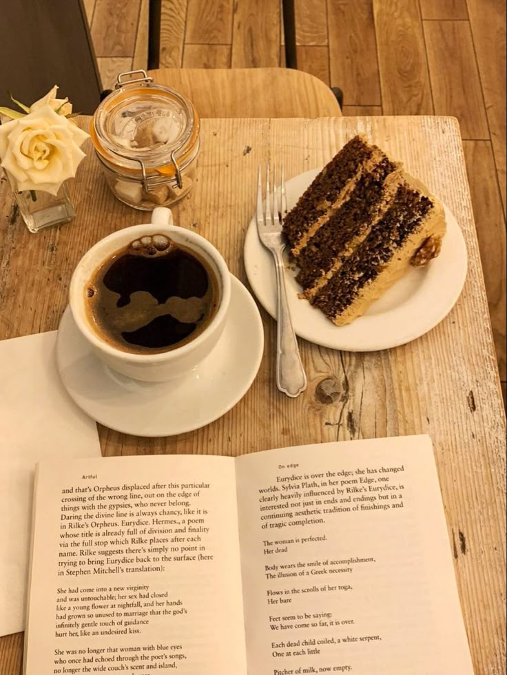 a piece of cake sitting on top of a table next to a cup of coffee