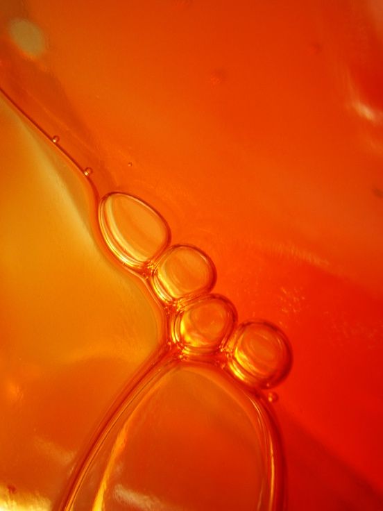 an orange glass vase filled with water and bubbles