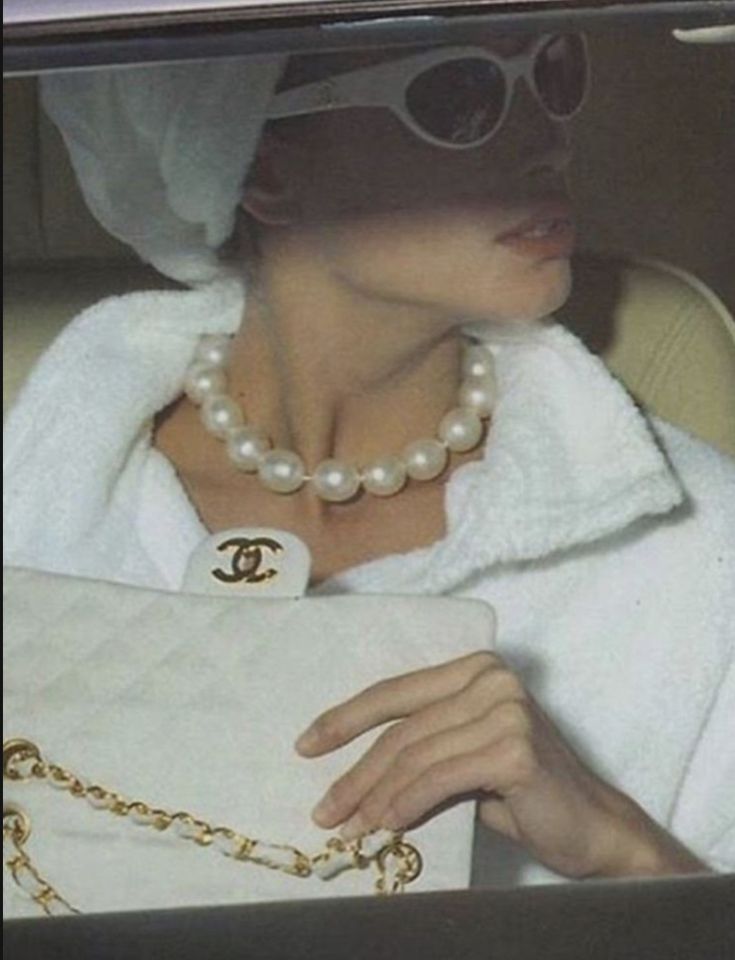 a woman in a car holding a white purse