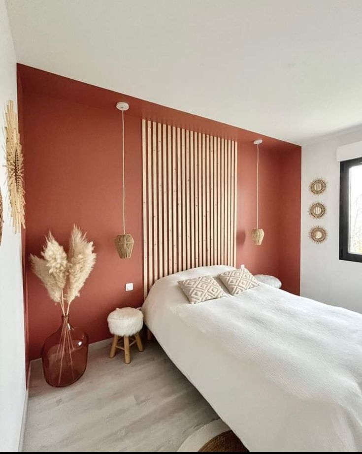 a bedroom with red walls and white bedding