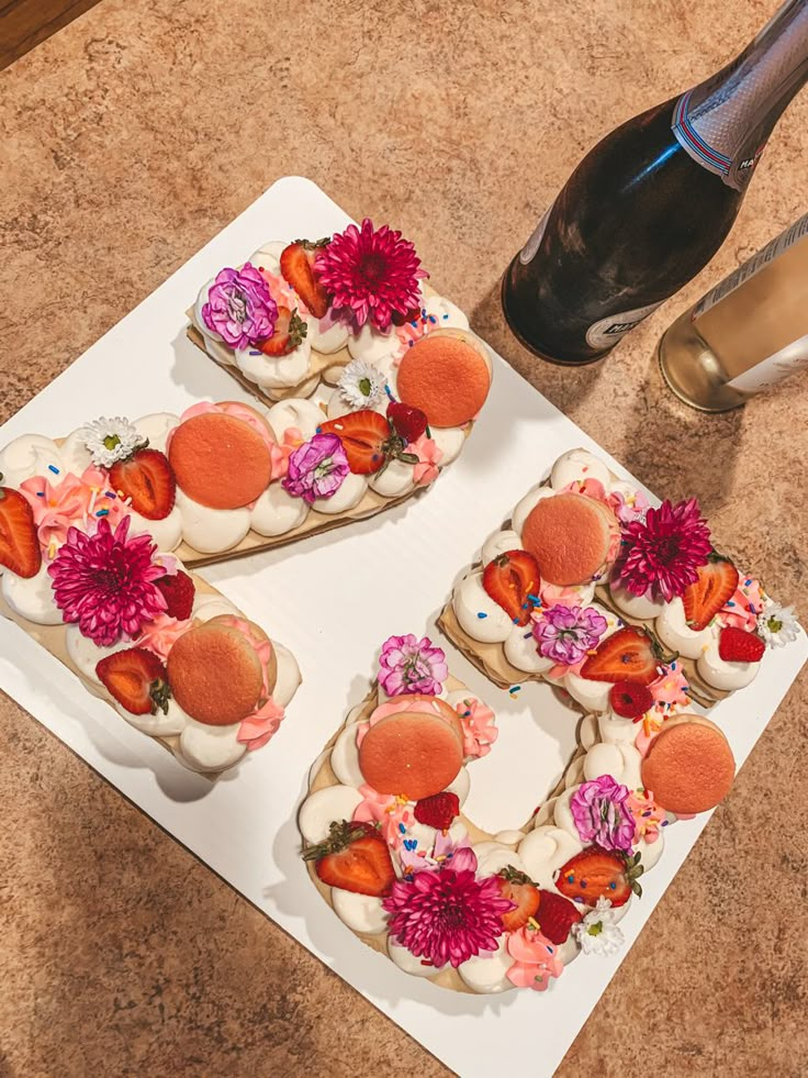 two slices of cake decorated with flowers on a plate next to a bottle of champagne