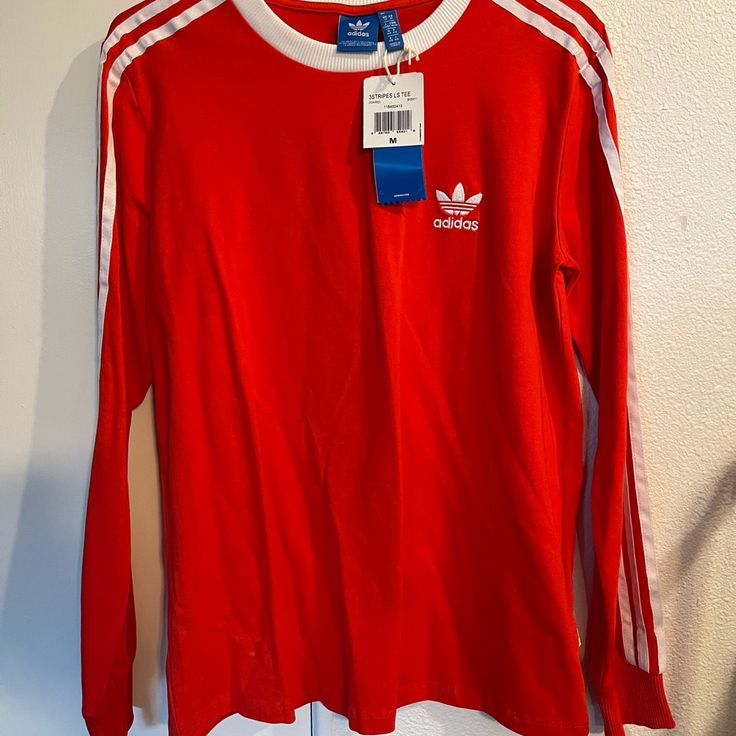 Brand New Red Adidas Long Sleeve Never Worn Red Long Sleeve T-shirt For Spring, Casual Long Sleeve Red T-shirt, Casual Red Long Sleeve T-shirt, University Red Long Sleeve Sporty Tops, Adidas Red Top With Three Stripes, Red Adidas Tops With Three Stripes Branding, Cotton Long Sleeve Top With Three Stripes, Cotton Tops With Three Stripes Long Sleeve, University Red Long Sleeve Top