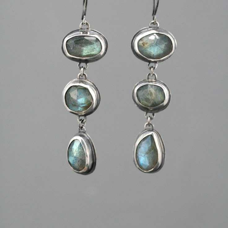 "These eye catching dangle earrings feature a row of three natural rose cut labradorite stones. They are a lovely soft grey with fascinating flashes of green and blue. They are lovingly set in handmade sterling silver bezel settings with sterling french ear wire. The silver has an oxidized finish with areas of high shine to create contrast.  The earrings measure 2 1/2\" from top to bottom." Labradorite Earrings, Dope Jewelry, Funky Jewelry, Jewelry Lookbook, Stone Work, Gem Stones, Bijoux Diy, Dream Jewelry, Pretty Jewellery