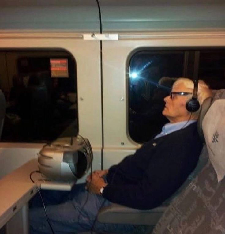 a man wearing headphones sitting on a train