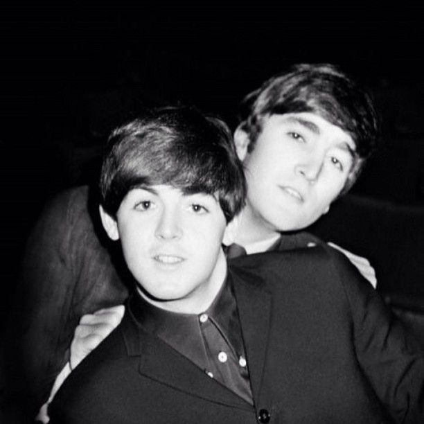 two young men are posing for a black and white photo, one is holding his arm around the other's shoulder