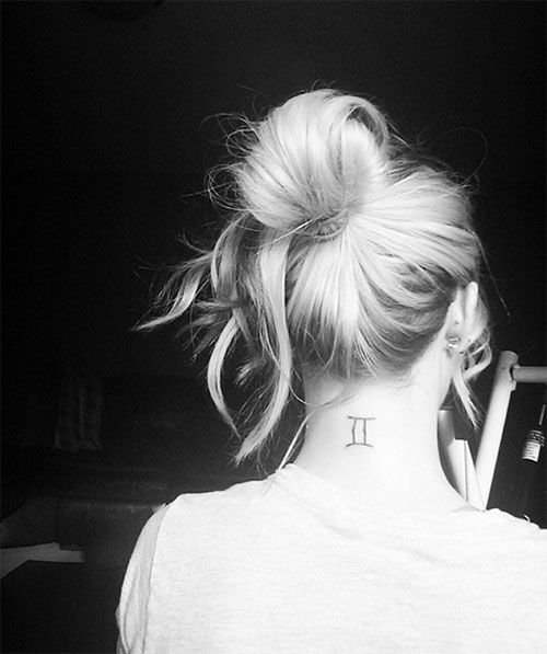 the back of a woman's neck with a small pi symbol tattoo on it