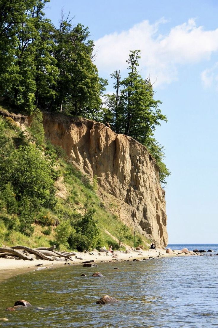 a boat is on the water near a cliff