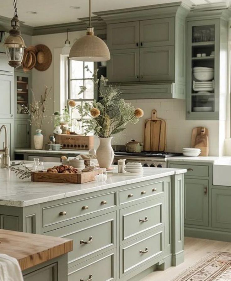 a kitchen filled with lots of green cupboards and counter top space next to a window