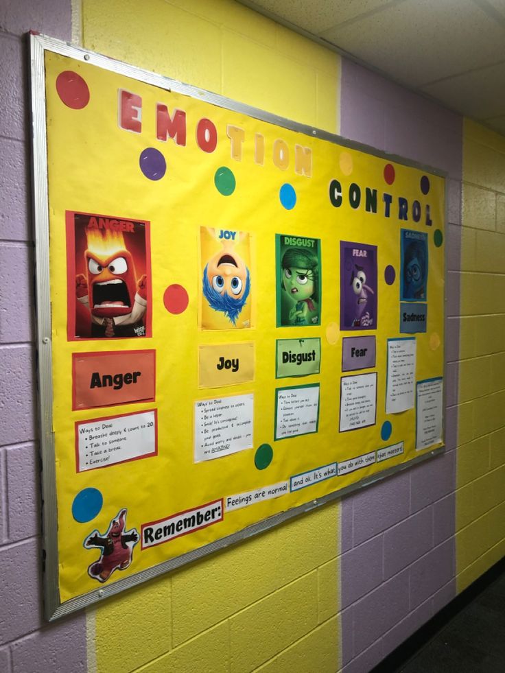 a bulletin board on the side of a wall in a school hallway with posters about emotions and feelings