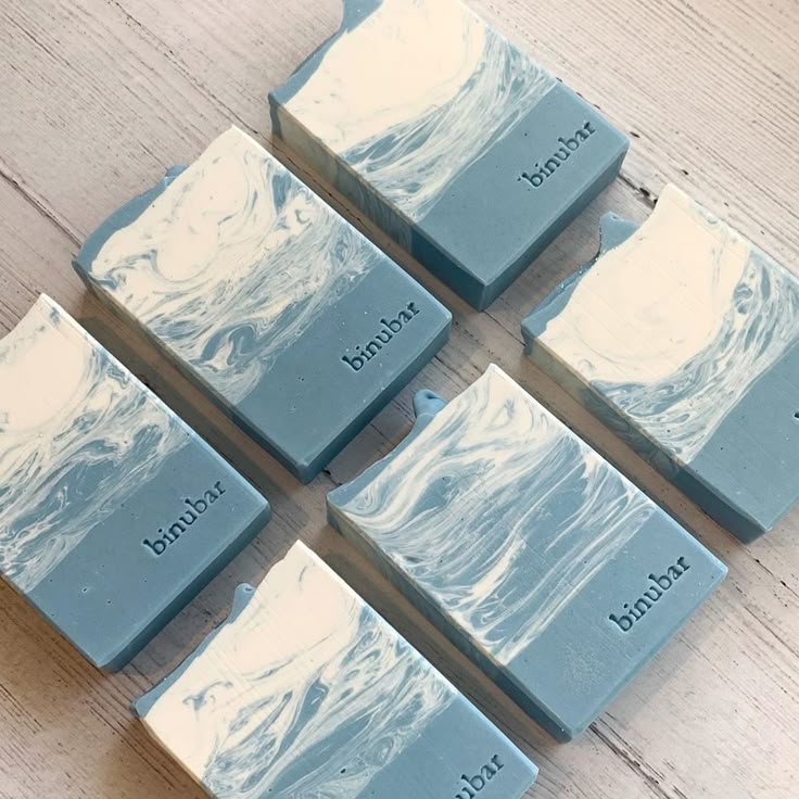 six blue and white soap bars sitting on top of a wooden table next to each other