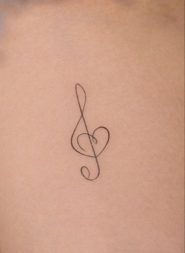 a musical note tattoo on the back of a woman's stomach