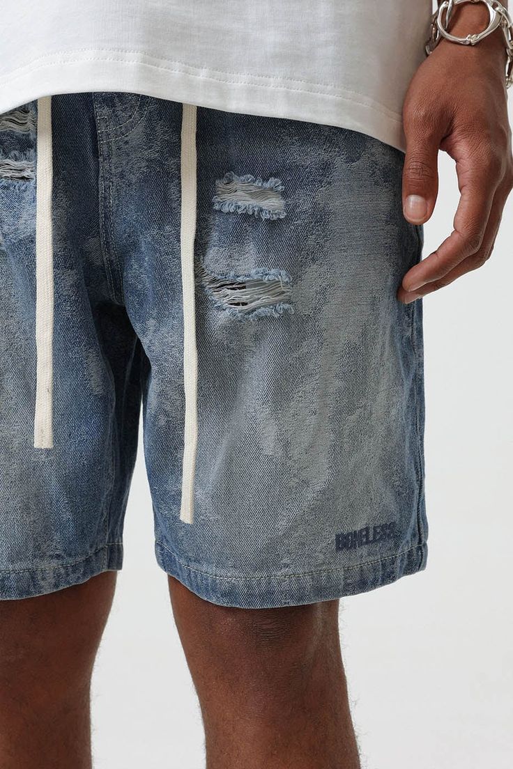 Bring an edgy touch to your casual wear with the Contrast Texture Ripped Denim Shorts. This pair is thoughtfully ripped throughout, adding a grungy twist to the classic washed blue color. With an elastic waistband design, which is highly unusual for denim shorts, you get the benefit of both style and comfort. The extended drawstrings allow for a customizable fit, adding to the unique appeal of these must-have shorts. Ripped throughout for a grungy aesthetic Classic washed blue color Elastic wais Contrast Texture, Shorts Ripped, Waistband Design, Cami Shirt, Mens Cardigan Sweater, Ripped Denim Shorts, Varsity Jacket Men, Distressed Denim Shorts, Ripped Denim