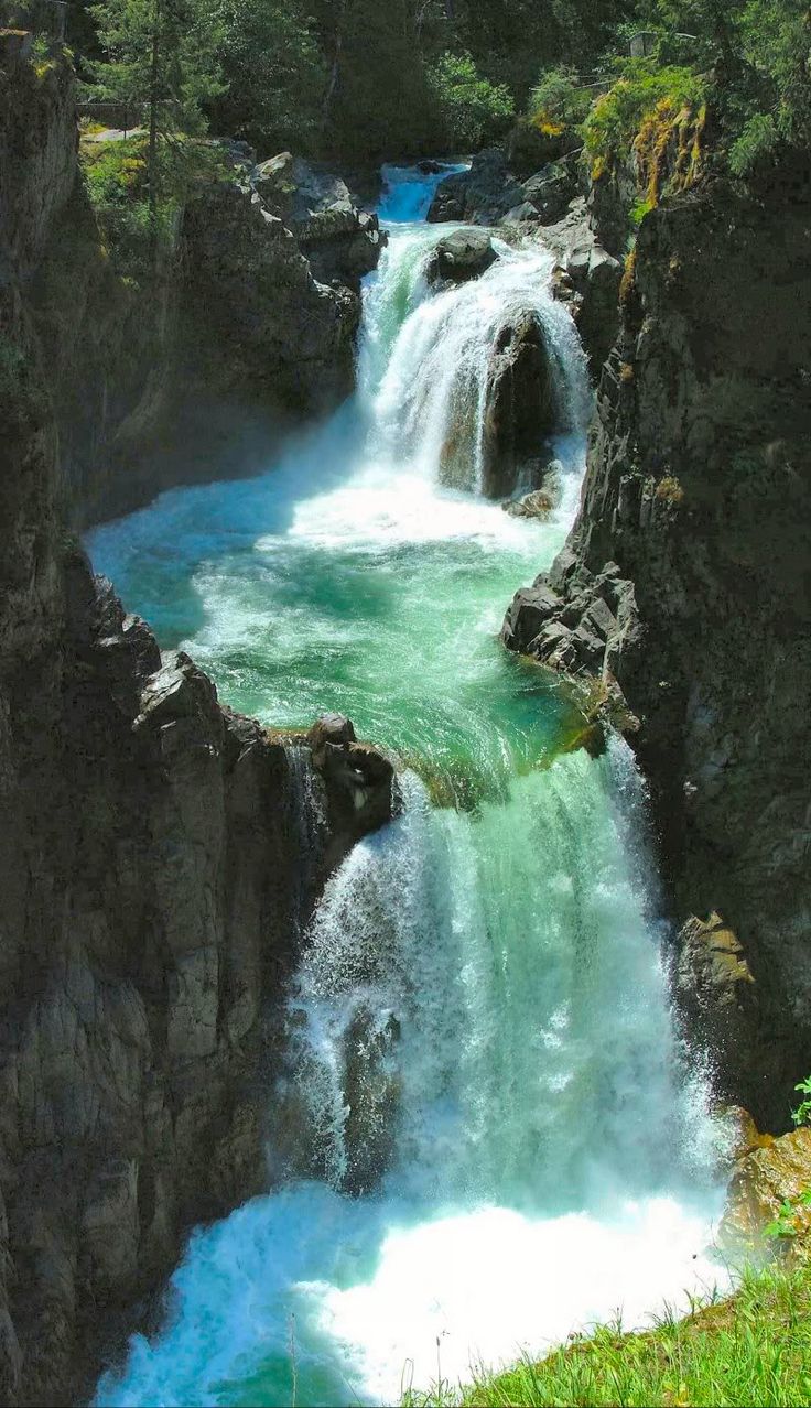 the water is blue and green as it flows through the rocks in the river bed