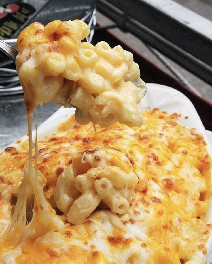 a spoonful of macaroni and cheese being lifted from a plate