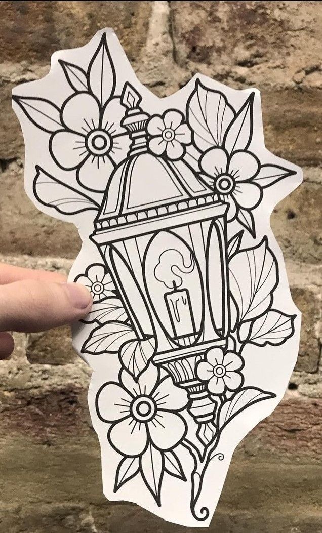 a hand holding up a sticker with flowers on it and a lamp in the middle