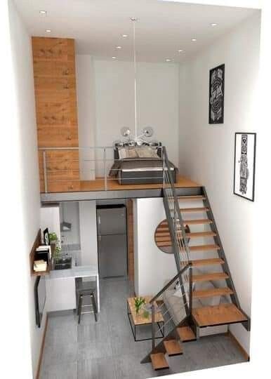 the stairs lead up to an open kitchen and dining area in this small apartment with wood flooring