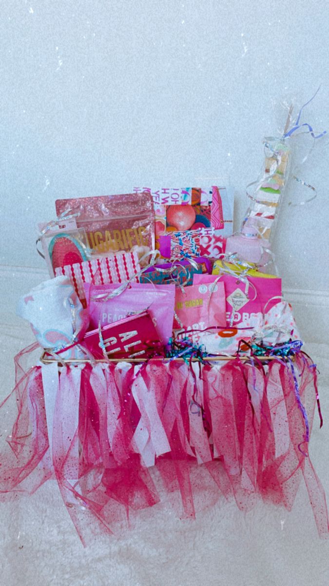 a pink table topped with lots of gifts