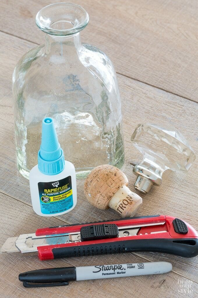 some tools are laying on a table next to a bottle and corkscrews