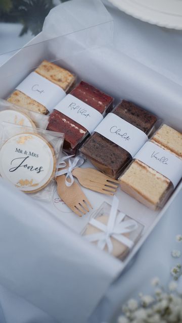 a box filled with lots of different types of cakes and desserts on top of a table