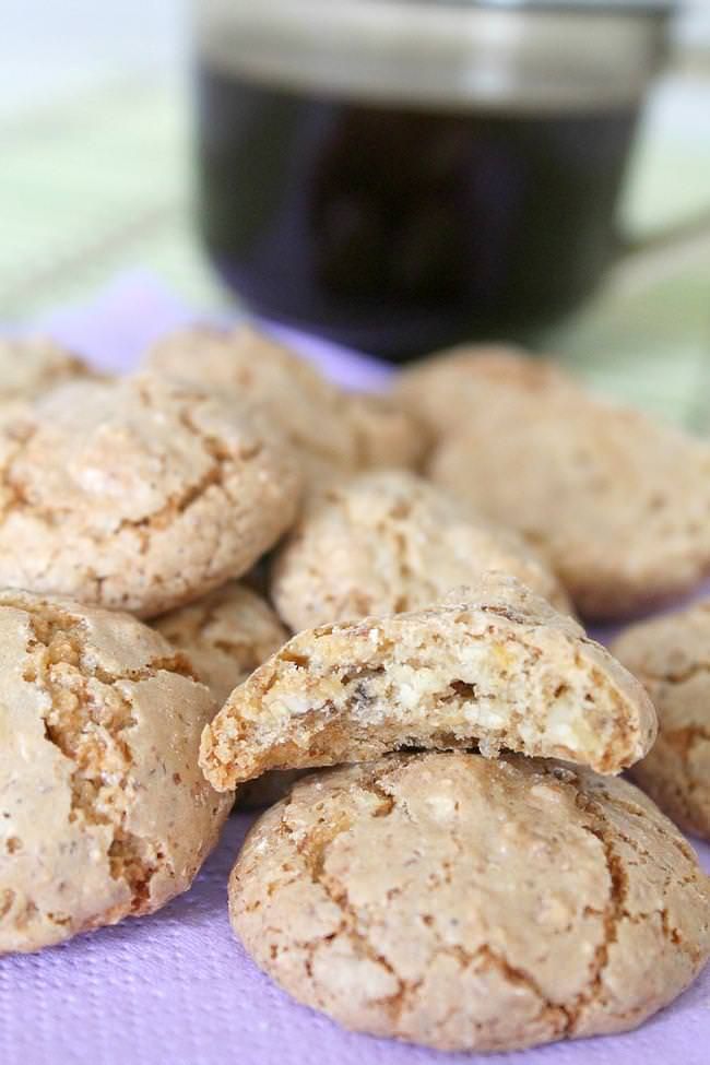 some cookies are on a purple towel next to a cup of coffee and a glass of wine