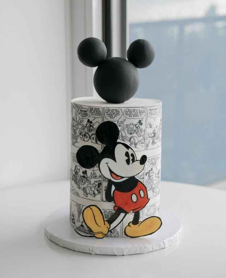 a mickey mouse cake with black and white designs on it's top, sitting on a table