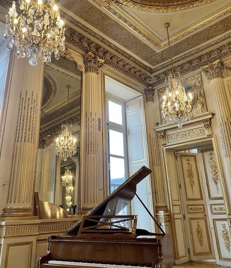 a grand piano in an ornate room with chandelier