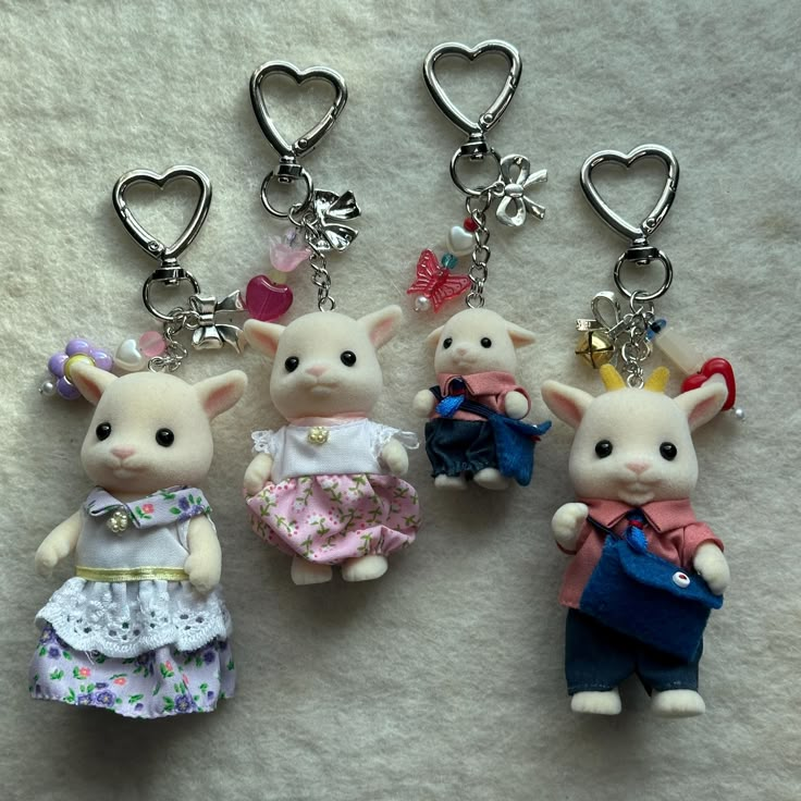 three key chains with little mice on them, one wearing a dress and the other holding a purse