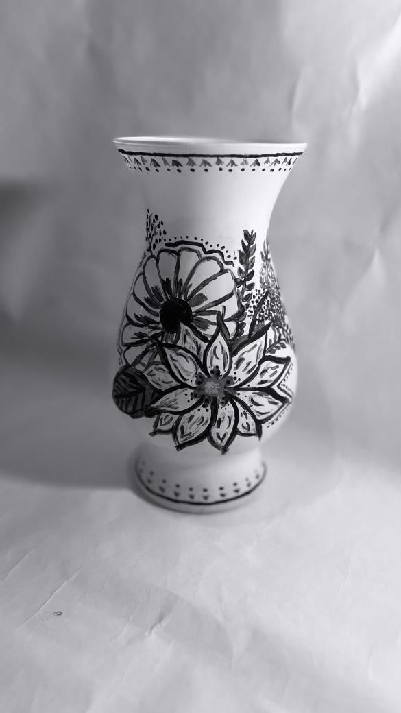 a black and white photo of a vase with floral designs on it's sides